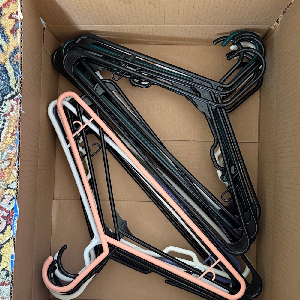 Assorted plastic hangers, black / white/ colors most unused / used once count 25